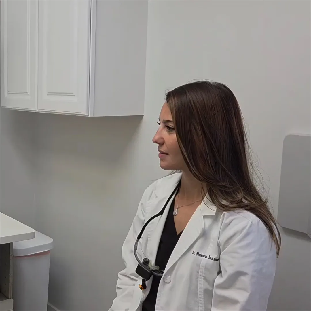 Dr. Jaamour smiling as she talks in a treatment room at Pearl Dental Care