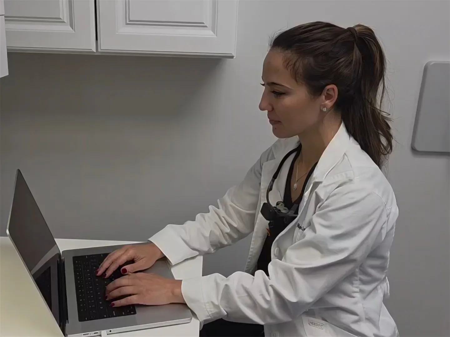 Dr. Jaamour pointing at her laptop screen in a treatment room at Pearl Dental Care